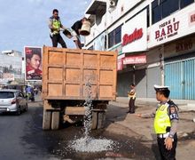 Keren Pak Polisi, Bantu Menutup Lubang Jalan Raya Supaya Enggak Bahaya