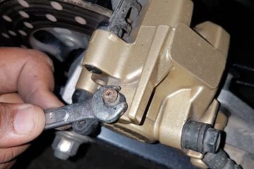 Kendorkan nipple yang ada kaliper rem untuk mengendorkan rem