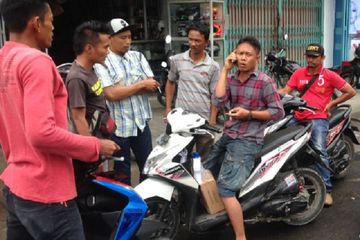 Ilustrasi debt collector memberhentikan pemotor yang menunggak cicilan.