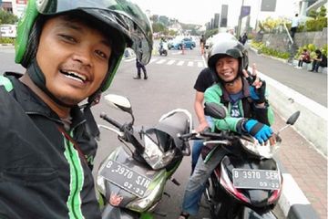 Dua driver ojol selfie di pinggir jalan.