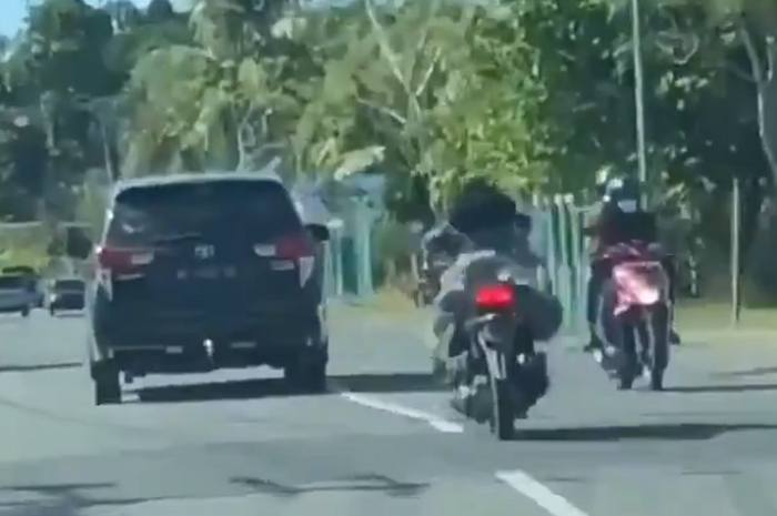 Atraksi cewek free style gaya superman di motor
